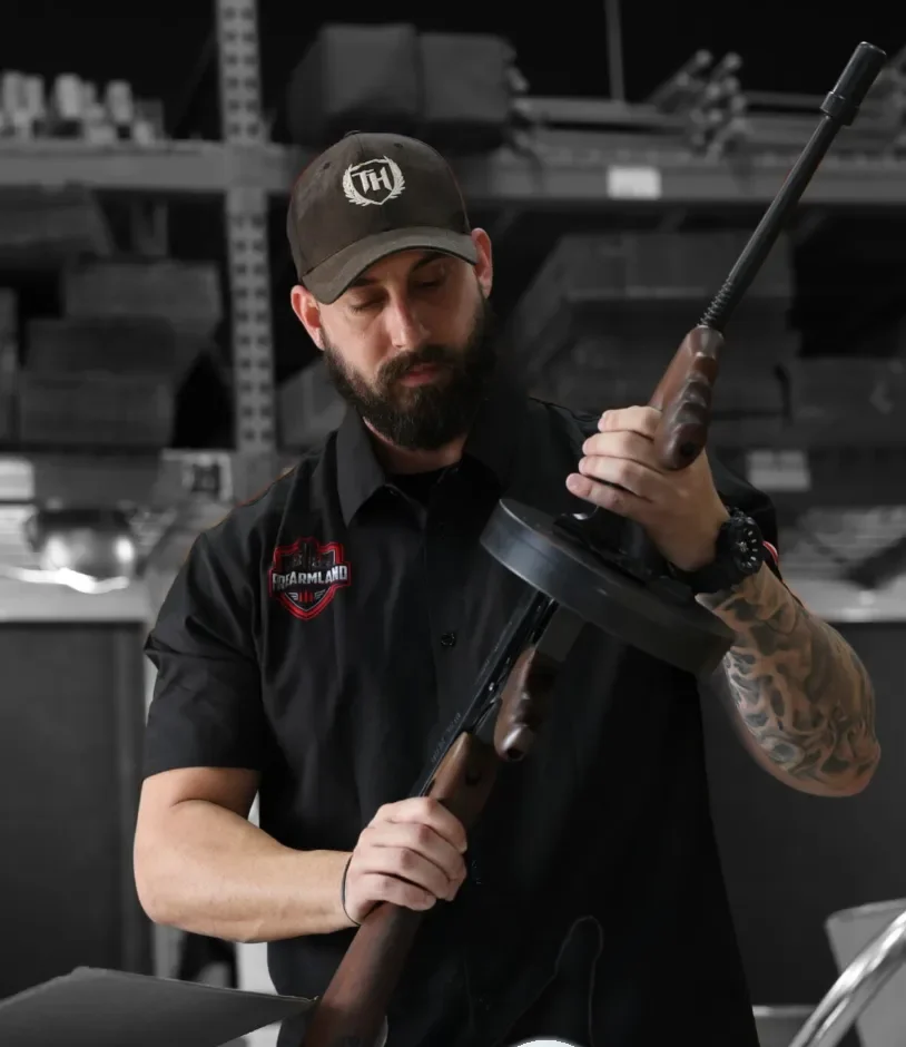 A FirearmLand staff member inspecting a firearm at our intake bench
